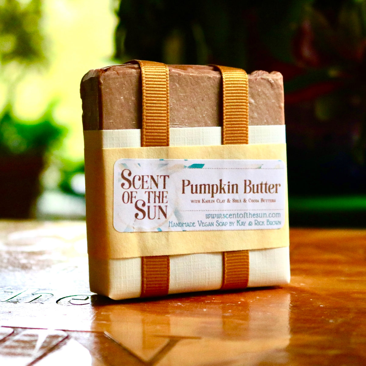 Wrapped bar of Pumpkin Butter vegan bar soap, contained within a paper wrapping and an orange ribbon. The plant-based bar is made of cruelty-free, plant-based ingredients.