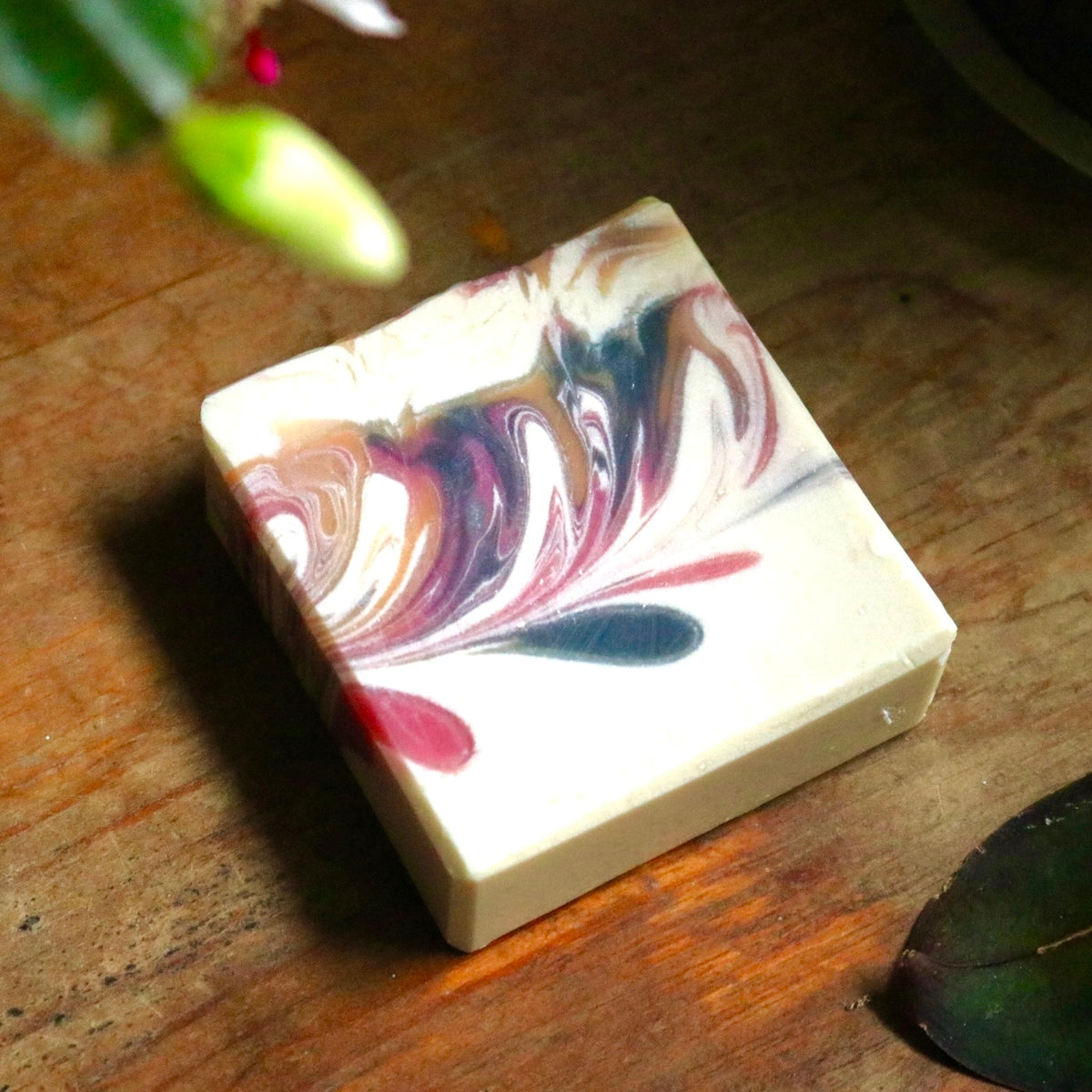 Another bar of vegan, plant-based Winter Maiden bar soap atop a wooden background.